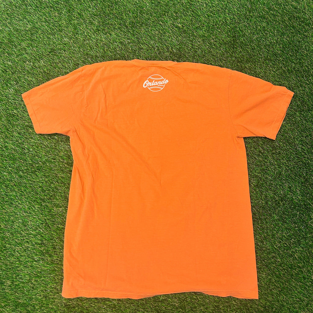 Orange t-shirt with a logo on a green grass background
